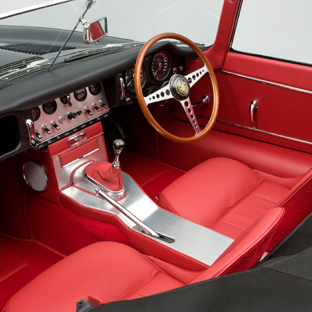 Front seat red leather interior of a classic black sports car funded by specialist car finance